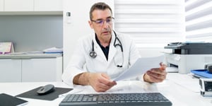 Doctor-reading-medical-examination-report-soc