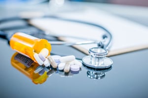 bottle-of-pills-spills-onto-desk-1067960972_600x400